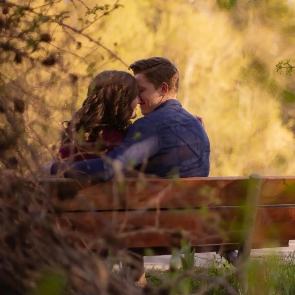 Pareja en una cita casual, en un lugar escondido, a punto de besarse.